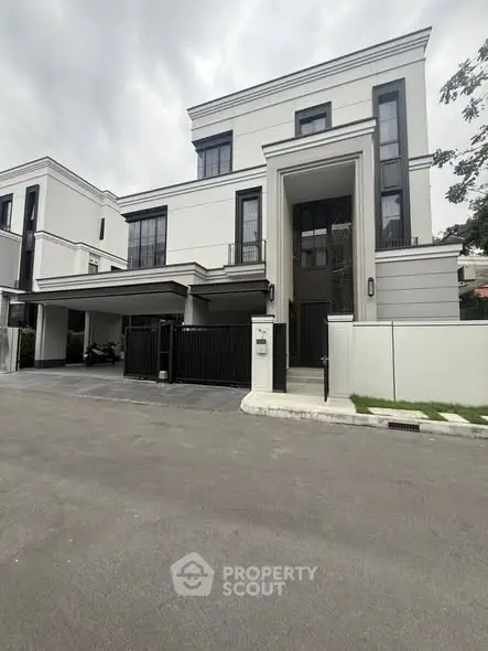 Modern luxury villa with sleek design and spacious driveway in upscale neighborhood.