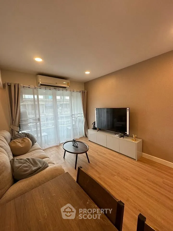 Cozy living room with modern decor and large TV, perfect for relaxation.