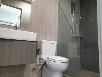 Modern bathroom with sleek fixtures and glass shower enclosure.