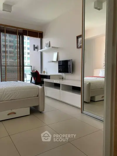 Modern bedroom with sleek design, featuring large windows and stylish furnishings in a contemporary apartment.