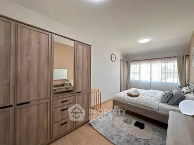 Spacious bedroom with wooden furniture and natural light