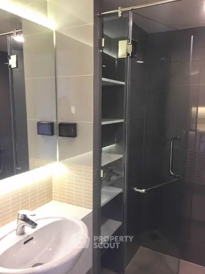 Modern bathroom with sleek glass shower and illuminated mirror