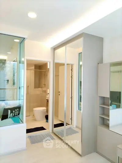 Modern bathroom with sleek design and mirrored closet doors in a bright apartment.