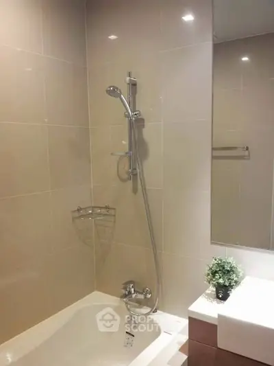 Modern bathroom with sleek shower and bathtub in contemporary apartment.