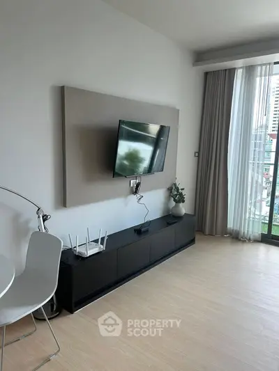 Modern living room with mounted TV and city view from balcony.