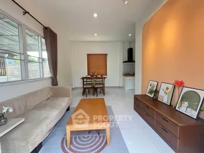 Charming living room with cozy sofa, wooden coffee table, and dining area in modern home.