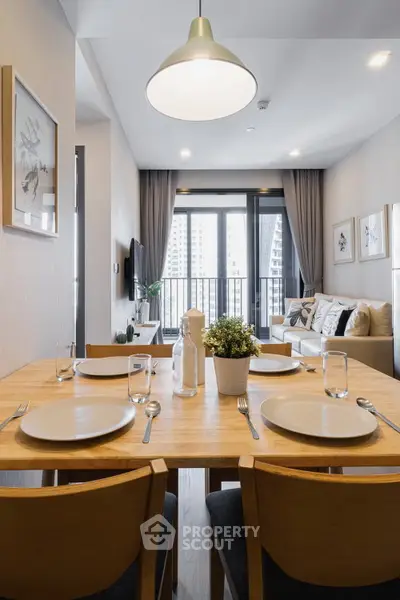 Modern dining area with elegant table setting and cozy living room view.