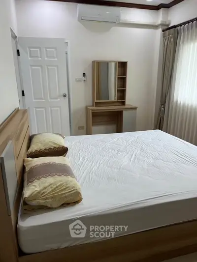 Spacious bedroom with modern wooden furniture and natural light