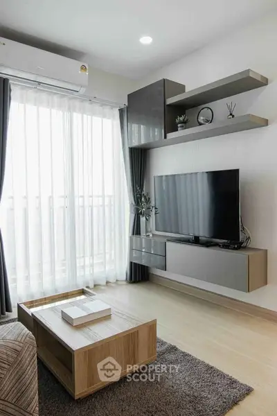 Modern living room with sleek furniture and large window, featuring a wall-mounted TV and stylish shelves.