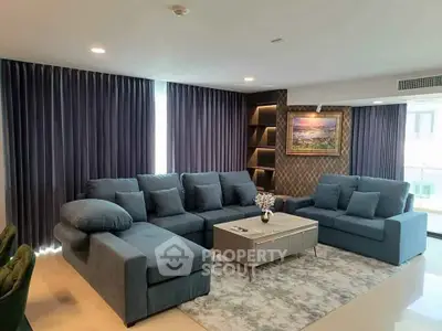 Spacious modern living room with elegant blue sectional sofa and stylish decor