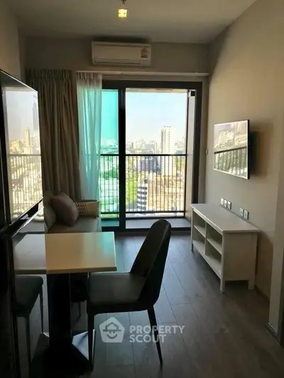Modern living room with city view and balcony access in high-rise apartment.