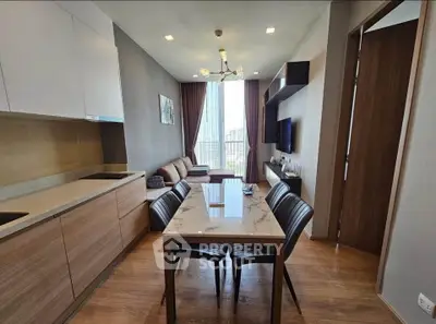 Modern living room with open kitchen and stylish dining area in a high-rise apartment.