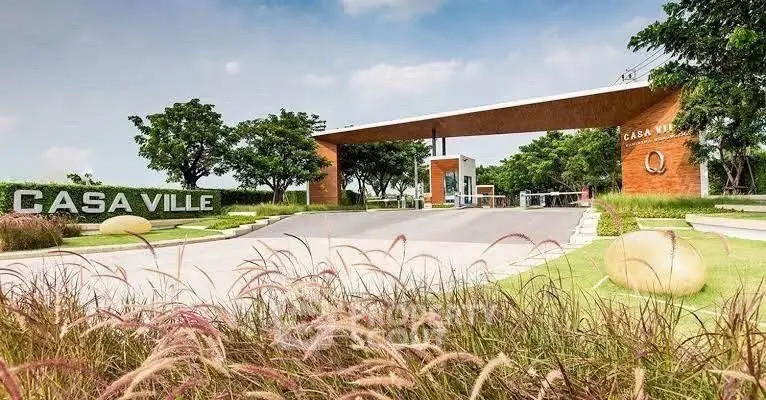 Modern gated community entrance with lush landscaping and clear skies.