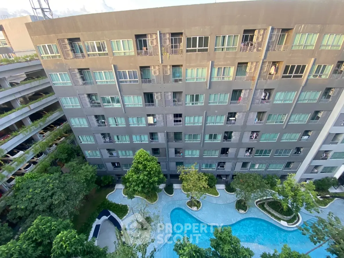 Modern condominium with pool view and lush greenery in urban setting