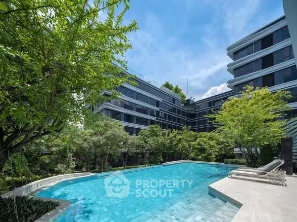 Luxurious modern apartment complex with stunning pool and lush greenery