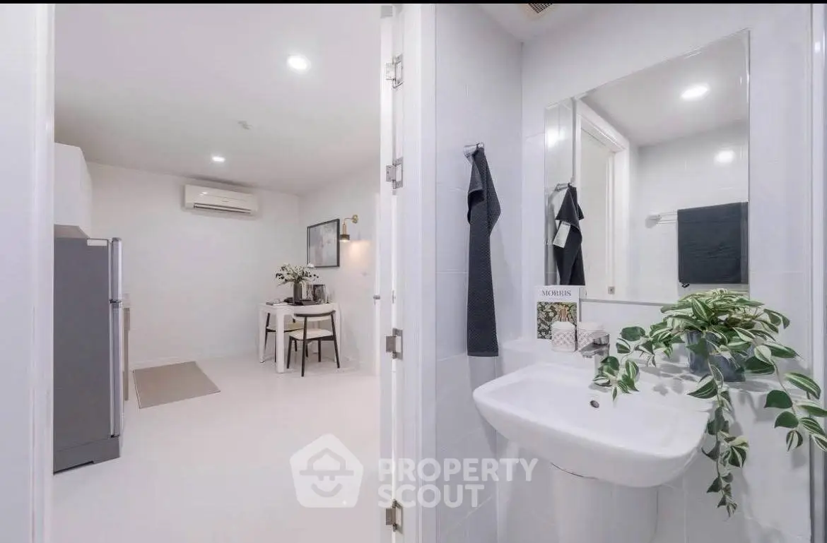 Modern apartment interior with sleek bathroom and dining area, featuring minimalist design and bright lighting.