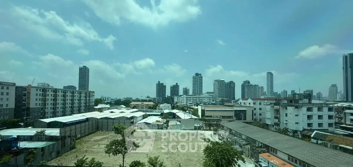 Panoramic cityscape view showcasing urban skyline and residential buildings under a clear blue sky.