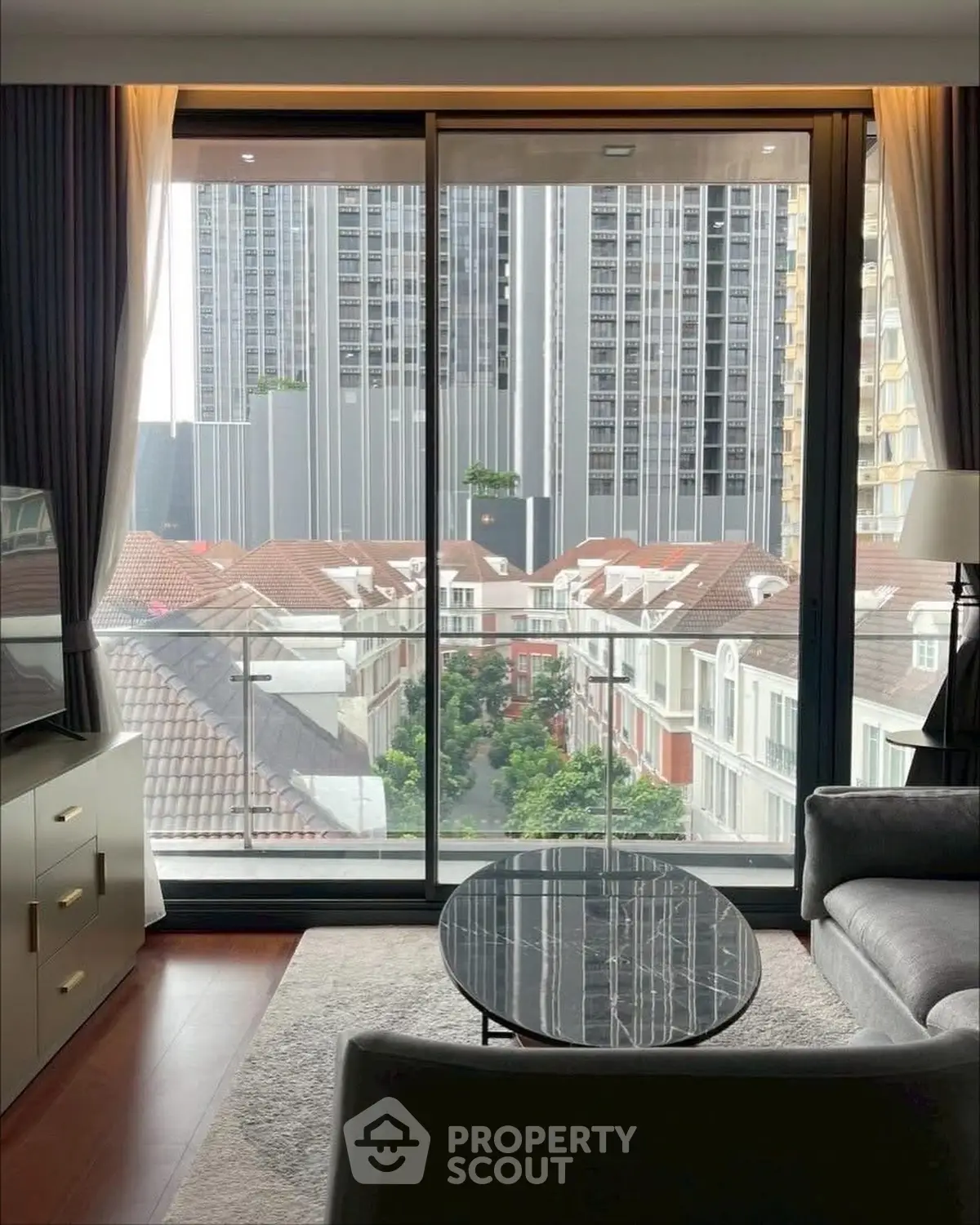 Luxurious living room with stunning city view from high-rise apartment balcony.
