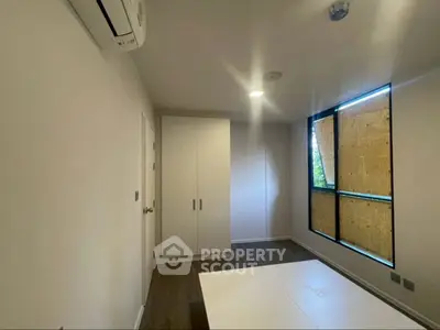 Spacious attic room with sloped ceiling and large window