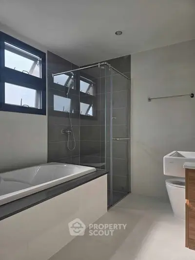 Modern bathroom with bathtub and glass shower enclosure