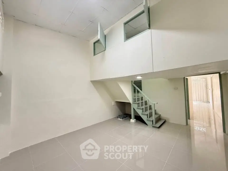 Spacious minimalist interior with loft and staircase, ideal for modern living.