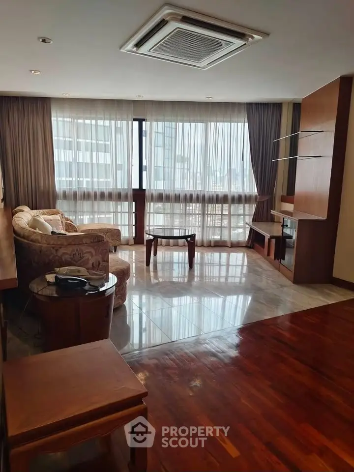 Spacious living room with elegant furniture and large windows offering natural light.