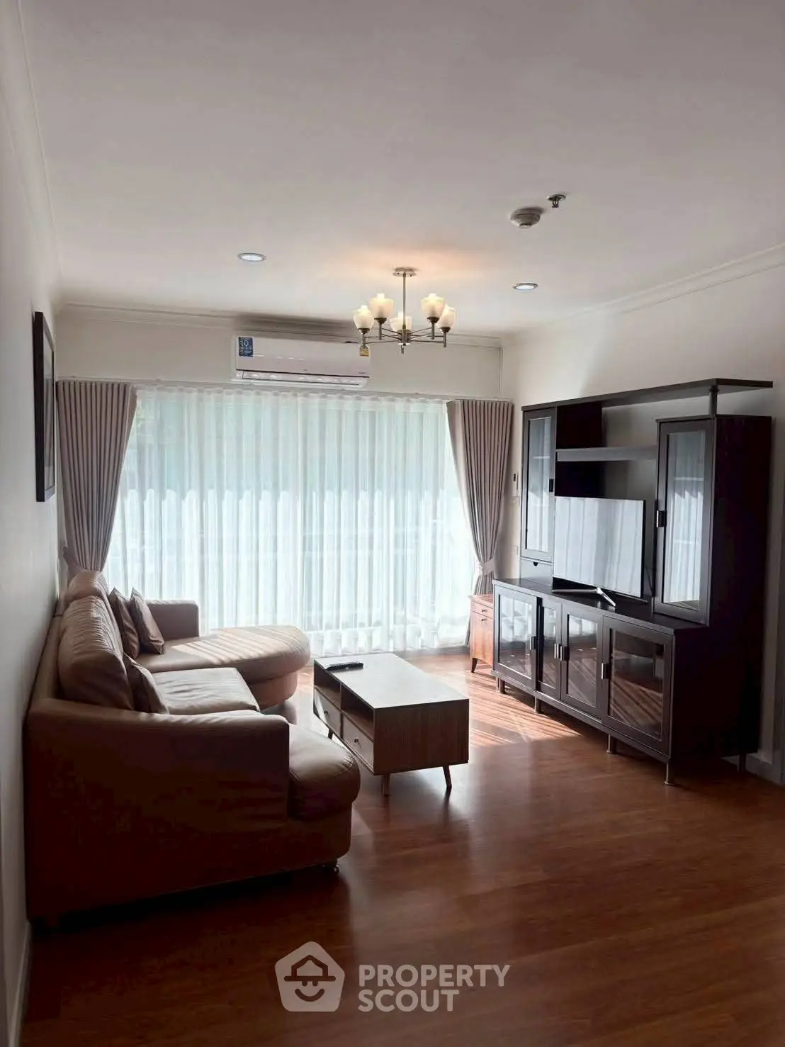 Spacious living room with elegant furniture and large window for natural light.