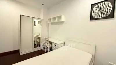 Minimalist bedroom with white furniture and geometric wall art