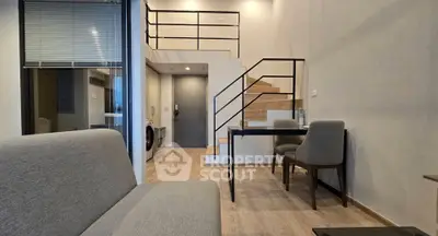 Modern duplex apartment with stylish staircase and cozy living area, featuring a washing machine and sleek furniture.