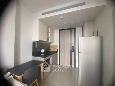 Modern compact kitchen with sleek appliances and dining area in stylish apartment