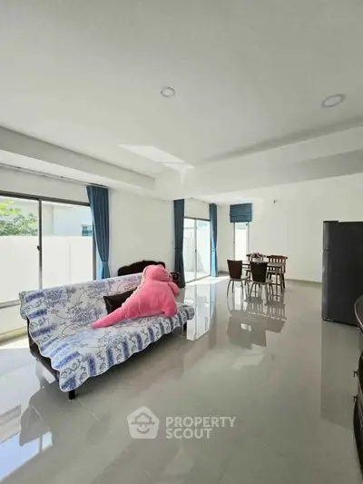 Spacious living room with modern decor and large windows for natural light