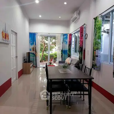 Spacious living room with modern decor and large windows offering garden views.