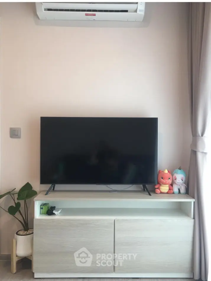 Modern living room with sleek TV setup and air conditioning unit.