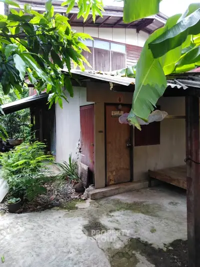 Charming rustic exterior with lush greenery and cozy outdoor space, perfect for nature lovers.