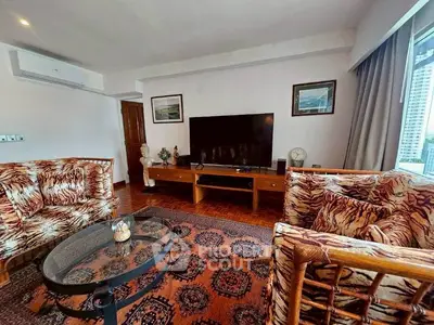 Spacious living room with stylish tiger print furniture and large TV, perfect for relaxation.