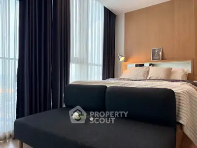 Modern bedroom with large windows and stylish decor, featuring a cozy bed and elegant lighting.