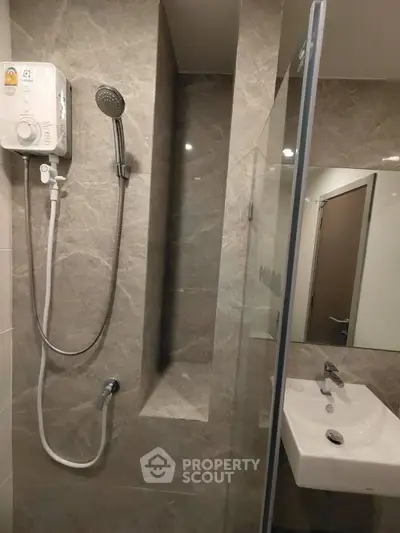 Modern bathroom with sleek shower and stylish sink in a contemporary apartment.