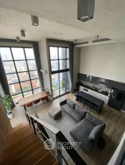 Stunning loft apartment with high ceilings and panoramic city views, featuring modern open-plan living area.