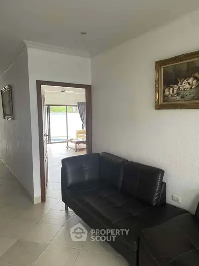 Spacious hallway leading to a bright living area with modern decor and pool view.