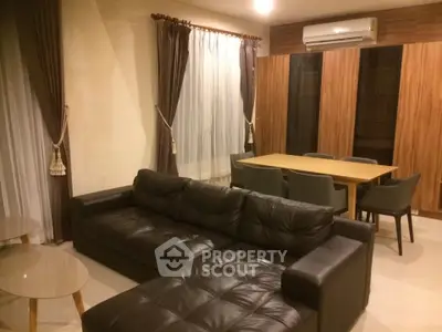 Spacious living room with modern leather sofa and elegant dining area