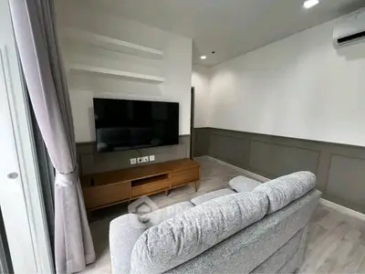 Modern living room with sleek TV setup and cozy gray sofa, perfect for relaxation.