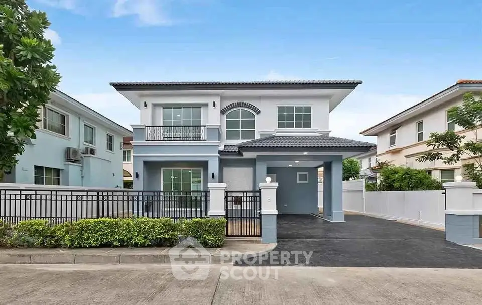 Modern two-story house with spacious driveway and elegant facade in suburban neighborhood.