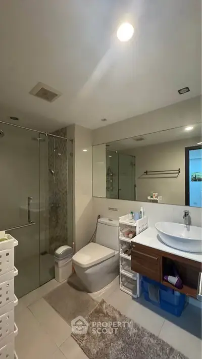 Modern bathroom with glass shower and stylish vanity in a contemporary home.