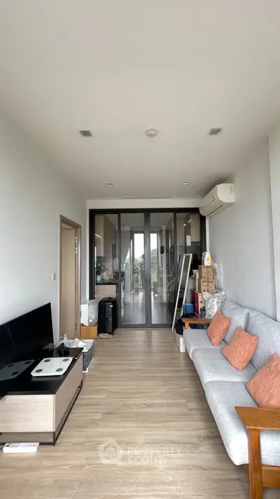 Modern living room with sleek design and cozy seating area, featuring air conditioning and stylish decor.