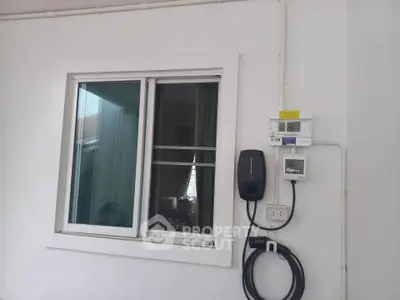 Modern home exterior with window and electric vehicle charging station