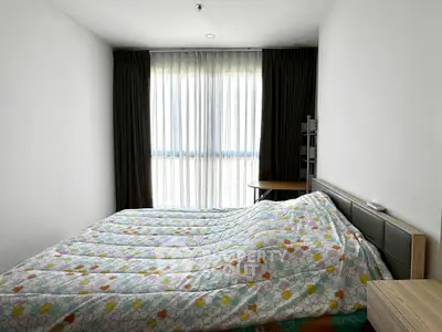 Cozy bedroom with large window and modern decor, perfect for relaxation and comfort.