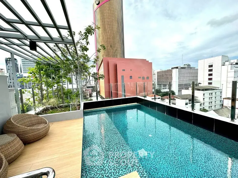 Luxurious rooftop pool with city skyline views and modern seating area.