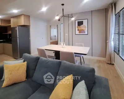 Modern open-plan living room with stylish dining area and cozy sofa.