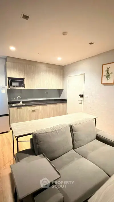 Modern open-layout kitchen with sleek cabinetry and cozy living area