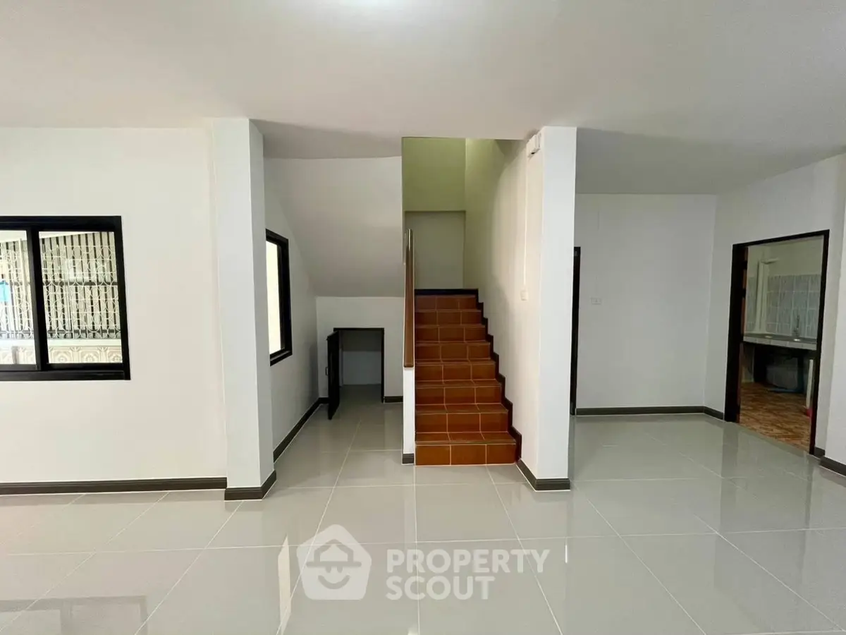 Spacious interior with modern tiled flooring and staircase in a bright home